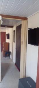 Zimmer mit einer Tür und einem TV an der Wand in der Unterkunft Casa en Barra del Chuy-Alvorada in Barra del Chuy + 22 Fotos