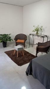a room with two chairs and a table and a bed at Flat no Garden III in Rondonópolis