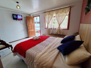 a bedroom with a large bed with a teddy bear on it at Hotel Las Cañas in Baños +37 photos