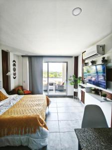 Un dormitorio con una cama y un televisor de pantalla plana. en Modern suite steps from the sea, en Santa Marta