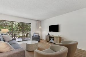 a living room with a couch and a tv at 2112 Beach Wood in Amelia Island