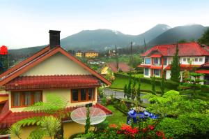 a group of houses with mountains in the background at Villa Buenavista Puncak in Puncak