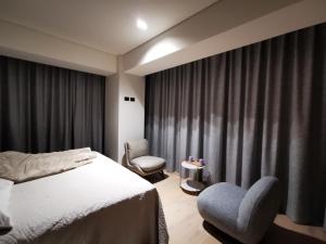 a bedroom with a bed and a chair and a window at Suite Exclusiva Corner Residencial Insurgentes 724 in Mexico City +62 photos