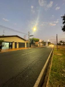 an empty street at dusk with a street light at Casa Coqueiros in Barretos