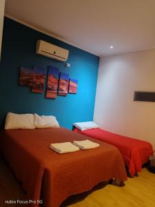a room with two beds and a blue wall at Abaucan alojamiento in Fiambala