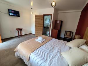 a bedroom with a bed with a towel on it at Hotel Las Cañas in Baños
