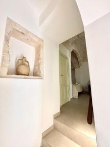 a hallway with a stairway with a vase on a shelf at Terratetto - Apulia in Ceglie Messapica +36 photos