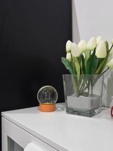 Un jarrón de flores blancas sobre una cómoda. en La dimora di Achille, en Bari 2 fotos más