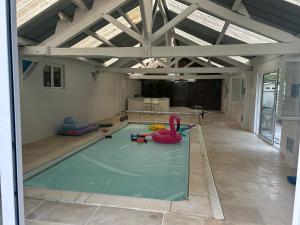 a swimming pool in a building with a room with a swimming pool at Maison Luna 2 in Salies-de-Béarn
