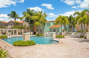 una piscina con palme e case di 1 Bedroom, Sofa Bed & Full Kitchen @ Las Casitas a Las Croabas