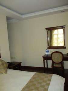 a bedroom with a bed and a table and a window at Sabean International Hotel in Āksum