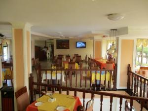 une salle à manger avec des tables, des chaises et une télévision dans l'établissement Sabean International Hotel, à Aksoum