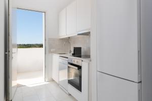 a kitchen with white cabinets and a stove at Sealove Villa in Lachania