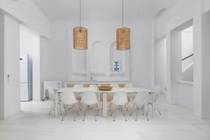 a white dining room with a table and white chairs at Sealove Villa in Lachania