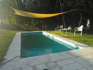 a swimming pool with a tent and a table and chairs at El Respiro in Victoria