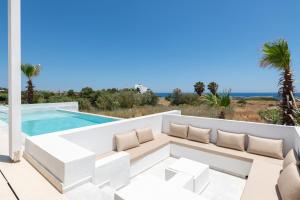 a patio with a couch and a swimming pool at Sealove Villa in Lachania