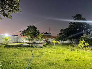 un patio verde con un edificio y un campo de césped en Chácara recanto do girassol, en Aquiraz 5 fotos más