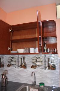 a kitchen with plates and dishes on a shelf at Hostal Corazon A Corazon in Chiclayo +57 photos