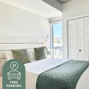 a white bedroom with a bed with a free parking sign at The 708 - For 4 - Free Parking - BBQ in Quebec City