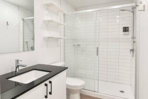 a bathroom with a shower and a sink and a toilet at The 708 - For 4 - Free Parking - BBQ in Quebec City +52 photos