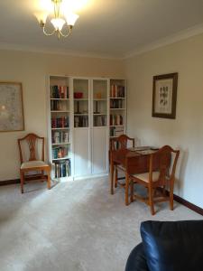 a living room with a table and chairs and book shelves at Cottage at the Hollow in North Middleton