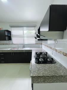 une cuisine avec une cuisinière et un évier dans l'établissement Casa con piscina, zona BBQ y seguridad privada, à Amalia