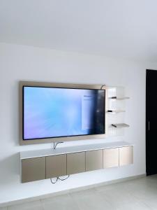 Elle comprend une télévision à écran plat sur un mur blanc. dans l'établissement Casa con piscina, zona BBQ y seguridad privada, à Amalia