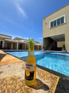 a bottle of beer sitting on a table next to a swimming pool at La Casa Lagoinha in Tigre