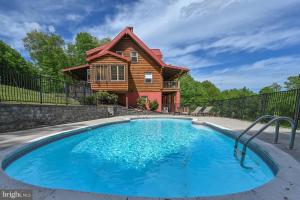 a log home with a pool in front of a house at Oakland Bear Lair in Oakland