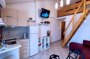 a kitchen with a white refrigerator and a staircase at Apartments and rooms by the sea Tucepi, Makarska - 6058 in Tučepi
