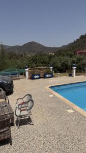 a patio with a pool and chairs next to a car at Villa Tikida - Paradise Valley in Aksri