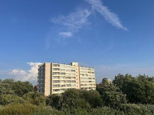 a tall white building with trees in front of it at Modern, Gemütlich, Strandnah in Cuxhaven