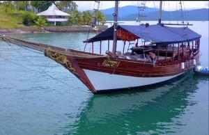 a boat is docked in the water on the water at IBIZA Escuna in Paraty