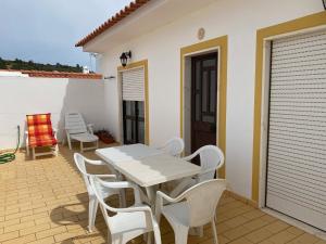 a white table and chairs on a patio at VilaMar in Salema