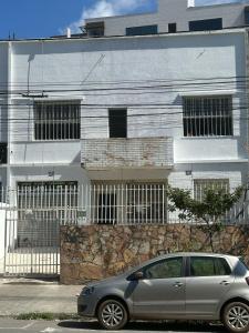 a silver car parked in front of a building at Quarto Aconchegante in Belo Horizonte