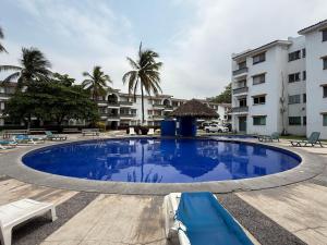 a large swimming pool in front of a building at Hermoso y moderno departamento 2Hab, club de paya in Manzanillo