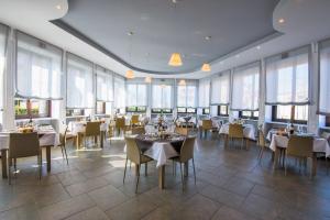 a dining room with tables and chairs and windows at Santanna in Verbania
