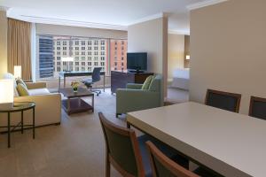a living room with a couch and a table and chairs at InterContinental Toronto Centre by IHG in Toronto