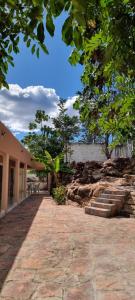 a stone walkway leading to a building with trees at Recanto das Pedras in Andaraí