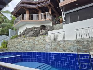 a house with an elephant on the wall next to a swimming pool at Eagles Nest Beach Resort Room 1 in Samal