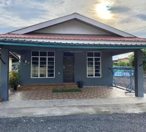 a small blue house with a porch at Habib Homestay in Kuala Terengganu