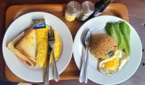 a tray with two plates of food with eggs and toast at Gili Tempoe in Gili Trawangan
