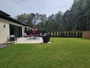 a patio with a table and chairs in a yard at Modern ranch retreat near Trilith and US Soccer Training Facilities in Fayetteville