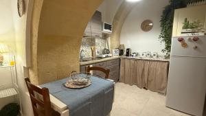a kitchen with a table and a white refrigerator at Casa IL Tempio in Siracusa