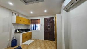 a kitchen with wooden cabinets and a door in a room at Eagles Nest Beach Resort Room 2 in Samal