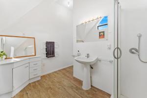 ein weißes Badezimmer mit Waschbecken und Dusche in der Unterkunft 5 Minutes Walk to Matakana Village in Matakana + 12 Fotos