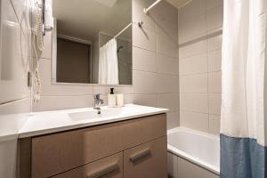 a bathroom with a sink and a mirror and a tub at Apartamento General Mackenna B&E in Santiago +22 photos
