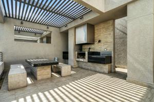 a room with a kitchen with a table and a ceiling at Apartamento General Mackenna B&E in Santiago