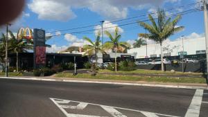 an empty street with a mcdonalds and palm trees at Kitnet central in Franca