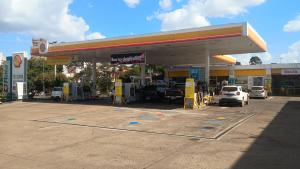 a gas station with cars parked in a lot at Kitnet central in Franca